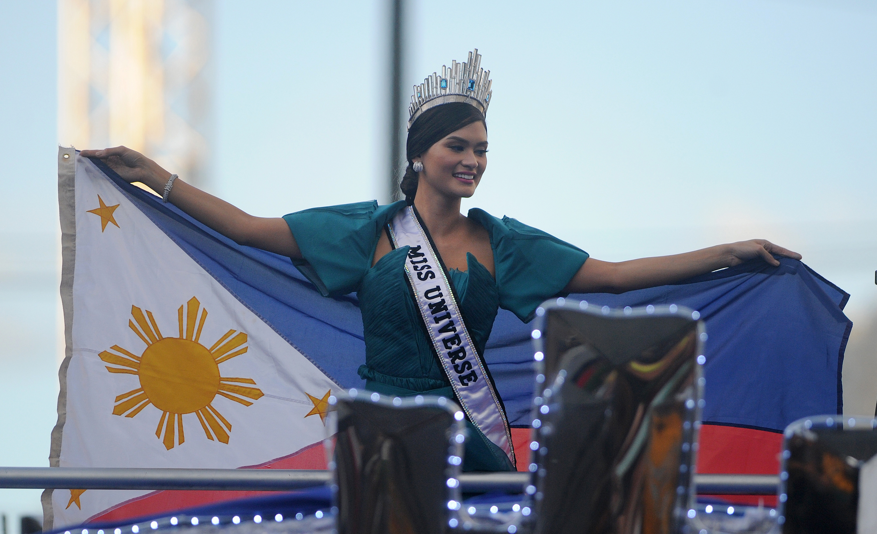 Miss Universe Pia Alonzo Wurtzbach waves a Philippine flag during her victory homecoming parade in Manila on January 25, 2016. Wurtzbach was crowned Miss Universe in December in a drama-filled show after the pageant's host, comedian Steve Harvey, misread his cue card and initially announced Miss Colombia as the winner before apologizing and saying Wurtzbach had won.     AFP PHOTO / NOEL CELIS / AFP / NOEL CELIS