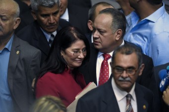 Diosdado Cabello (C), outgoing president of the National Assembly, arrives accompanied by First Lady and deputy Cilia Flores at the parliament in Caracas, on January 5, 2016. Venezuela's President Nicolas Maduro ordered the security forces to ensure the swearing-in of a new opposition-dominated legislature passes off peacefully Tuesday, after calls for rallies raised fears of unrest. AFP PHOTO/JUAN BARRETO / AFP / JUAN BARRETO