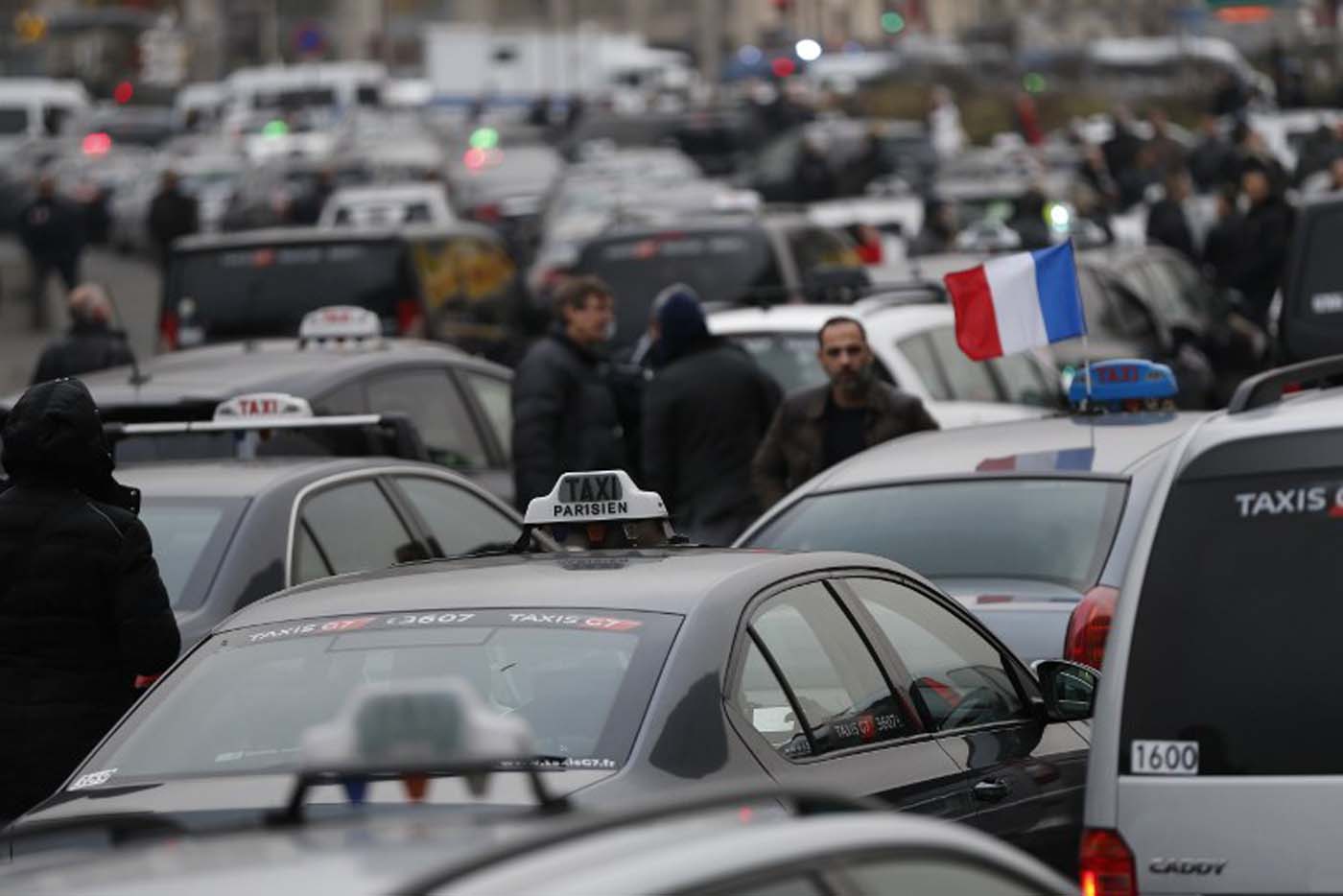 Taxi drivers block the traffic during a demonstration against the VTC (transport vehicle with chauffeur) on January 26, 2016 at porte Maillot in Paris. AFP PHOTO / THOMAS SAMSON / AFP / THOMAS SAMSON