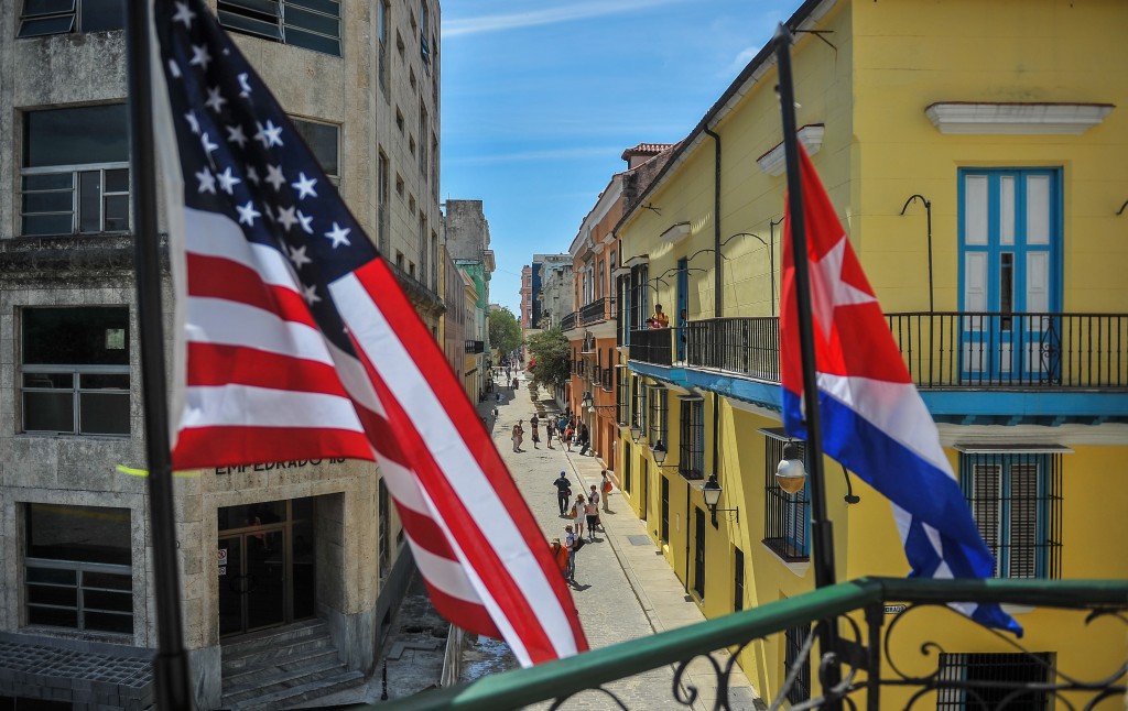 Cuban and US flags are seen outside the private restaurant La Moneda Cubana in Havana on March 17, 2016. Hundreds of workers have been scrambling for days to touch up building facades, patch potholes and spiff up Havana's monuments ahead of US President Barack Obama's visit. Obama next week will become the first US president to visit Cuba while in office in almost a century. AFP PHOTO/YAMIL LAGE / AFP / YAMIL LAGE