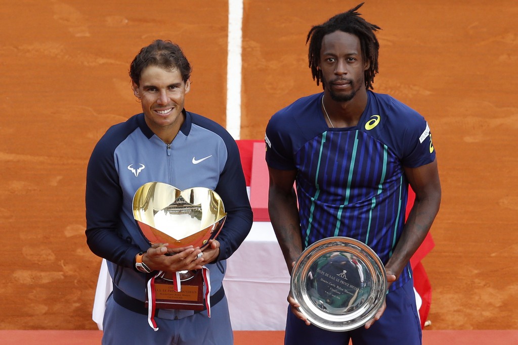 Winner Spain's Rafael Nadal and second placed France's Gael Monfils pose with their trophies during the awarding ceremony following the final tennis match at the Monte-Carlo ATP Masters Series Tournament in Monaco on April 17, 2016. Nadal defeated Monfils 7-5, 5-7, 6-0 to win a record ninth title at the Monte Carlo Masters.  AFP PHOTO / VALERY HACHE / AFP PHOTO / VALERY HACHE