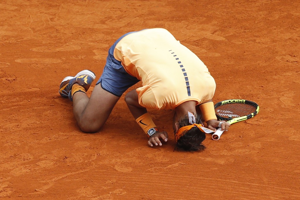 Spain's Rafael Nadal kneels on the court as he celebrates after defeating France's Gael Monfils during the final tennis match at the Monte-Carlo ATP Masters Series Tournament in Monaco on April 17, 2016.   AFP PHOTO / VALERY HACHE / AFP PHOTO / VALERY HACHE